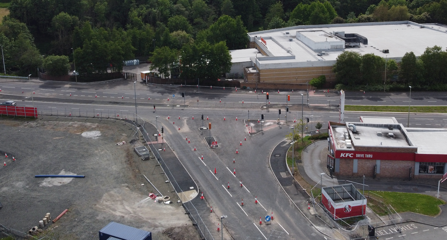 Aerial view of a T-junction with new road
                          to bottom, traffic islands but no traffic
                          lights