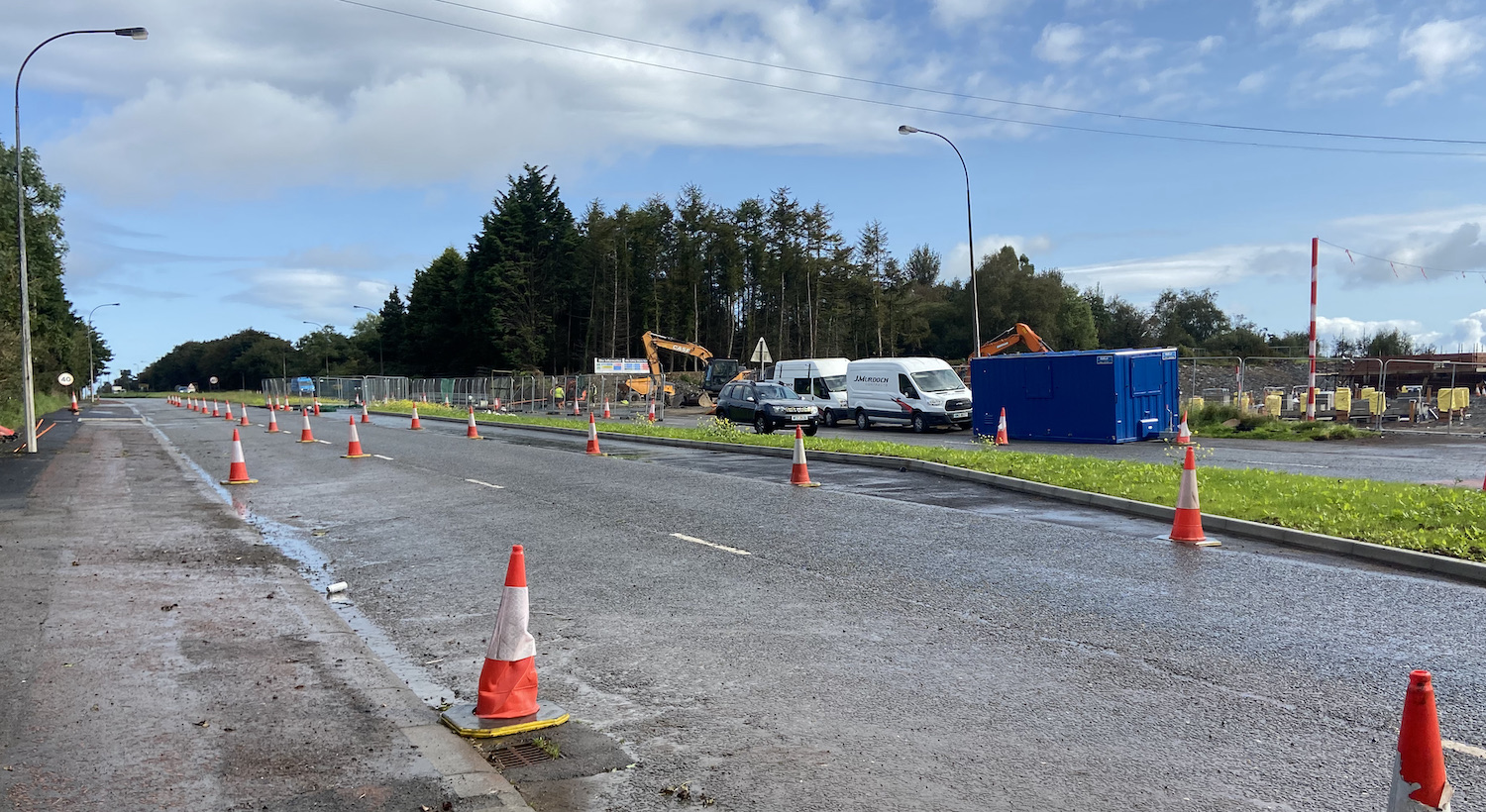 Two lanes coned to one with construciton
vehicles opposite.