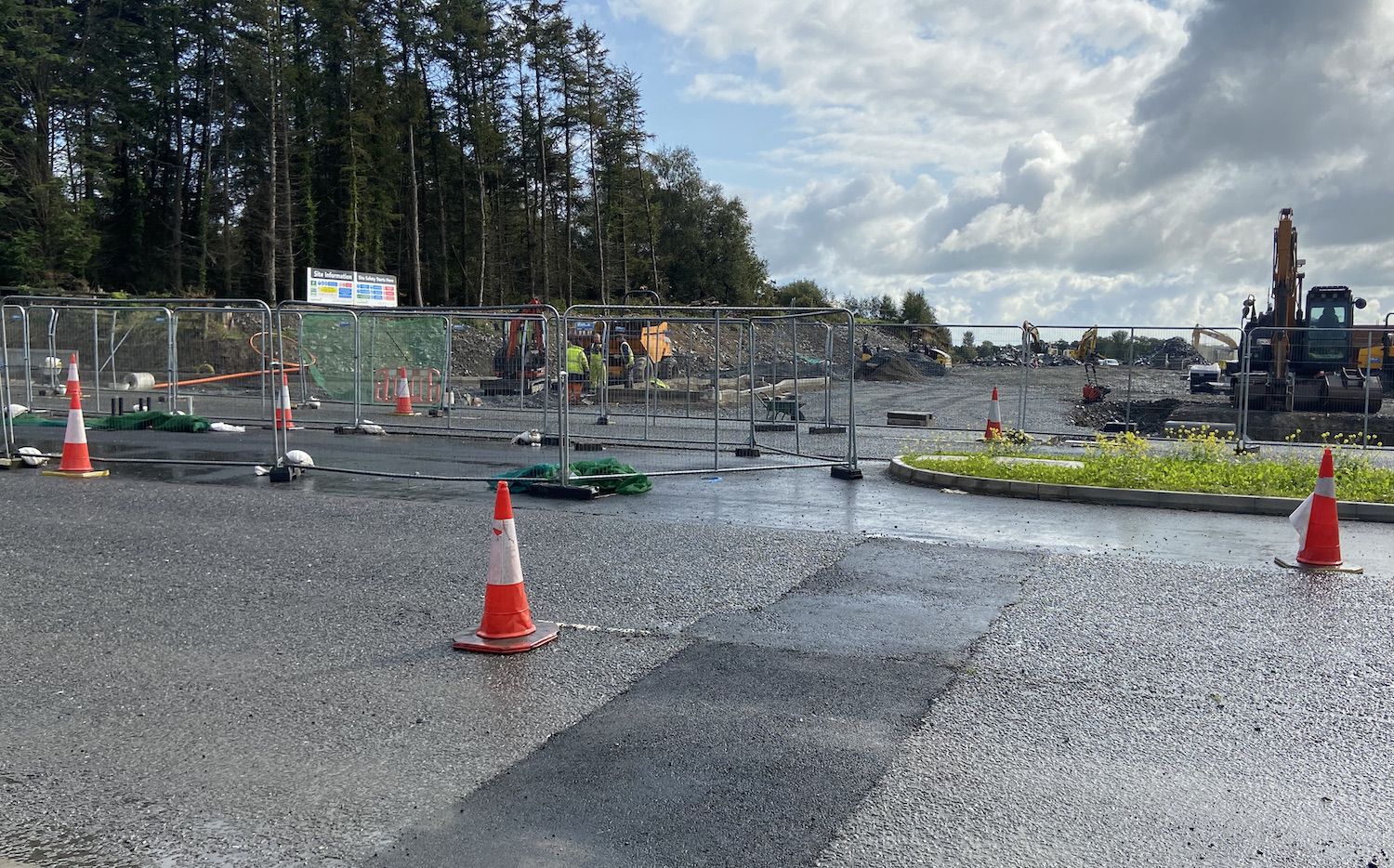 Looking across two lanes coned down to
one. A new right-turn lane is visible in the
central reservation. Building site beyond.