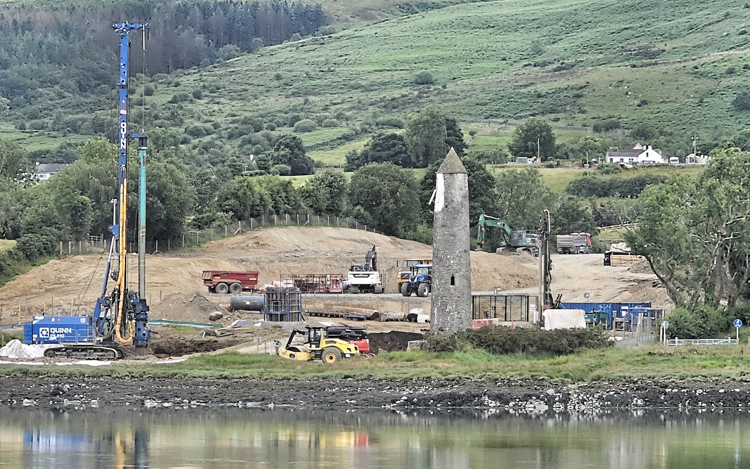 View across the river with a pile driver
on the left, the existing navigation tower on
the right and a lot of dug over earth in the
centre.
