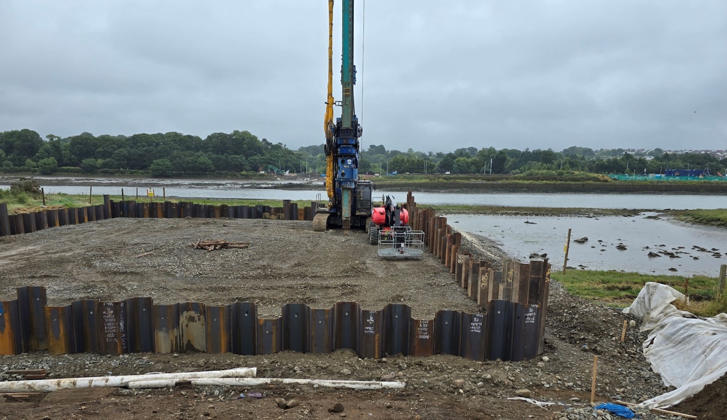 Square cofferdam seen from one side with
the river in the background. The cofferdam is
perhaps 20 metres on a side.