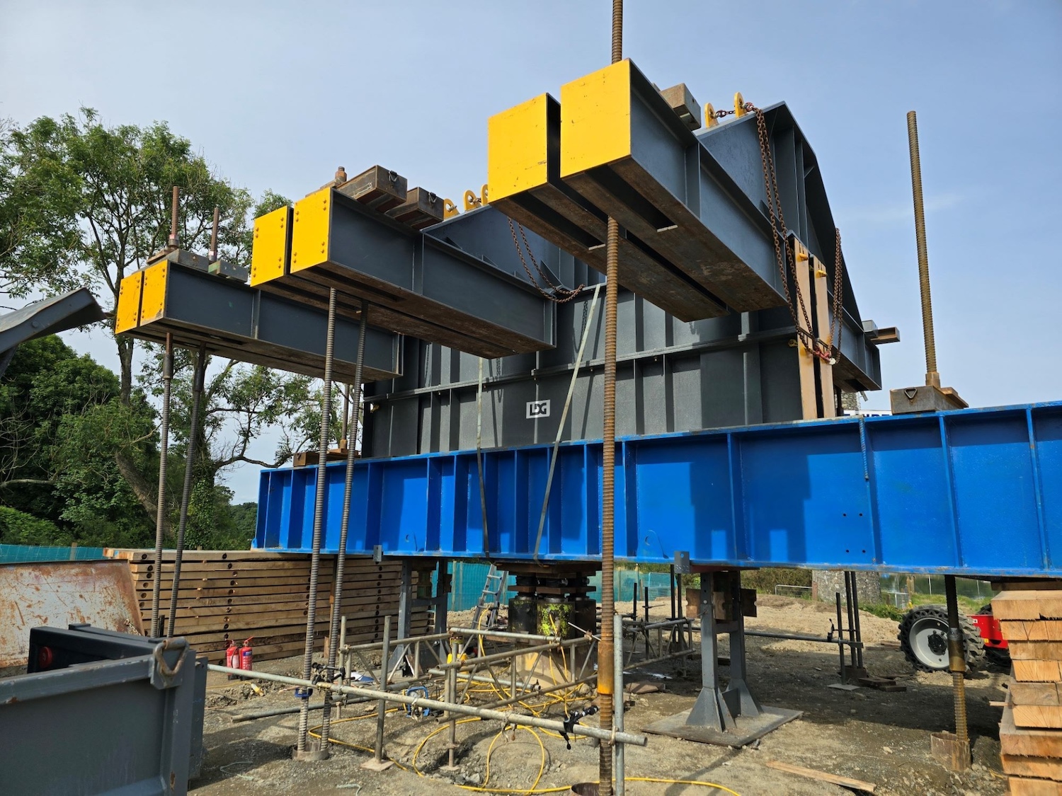 Large steel structure shaped like 3 Ts
side by side mounted on a blue steel beam.