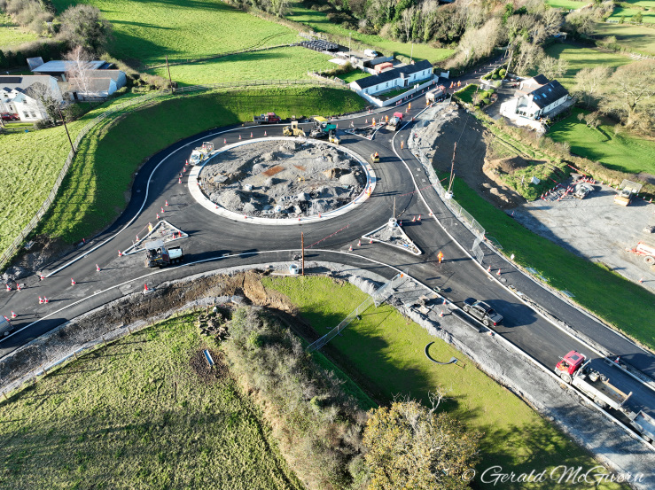 Roundabout in centre of shot with all
traffic moving around the far side only.